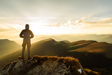 Silhouette of the man on top the peak of mountain on sunriseの写真素材