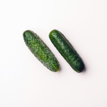 Green vegetables flat lay concept. Cucumber on white background, top view with empty space for text.の写真素材