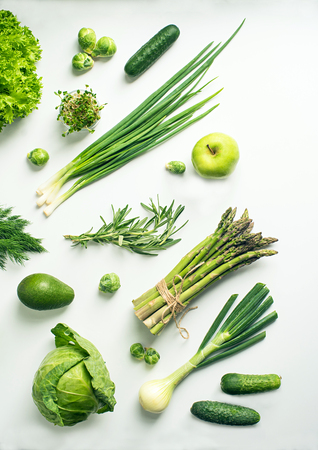 Green vegetables wide flat lay concept. Microgreens, brussels sprouts, asparagus, rosemary, avocado, onion, cabbage and cucumber on white background, top viewの写真素材