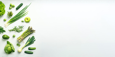 Green vegetables wide flat lay concept. Microgreens, brussels sprouts, asparagus, rosemary, avocado, onion, cabbage and cucumber on white background, top viewの写真素材