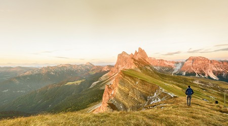 Silhouette of the man on top the peak of mountain on sunriseの写真素材