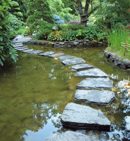 Stepping stones form walking path over the pond at nightの写真素材