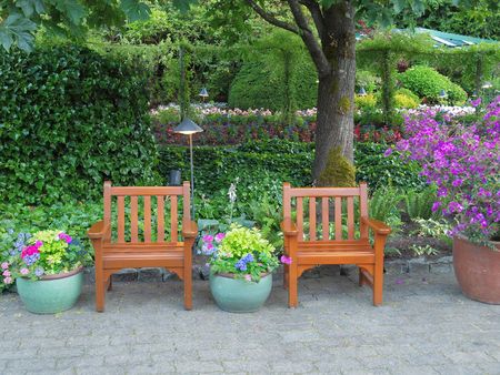 Chairs among lush greenery create a rest area in the parkの写真素材