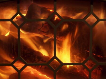 Fire blazing in the fireplace with decorative screenの写真素材