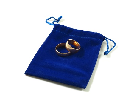 Two simple wedding rings on a blue velvet bag, isolated over whiteの写真素材
