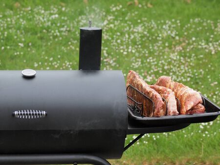 Portion of spareribs cooked on a charcoal smokerの写真素材