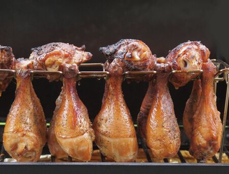 Portion of chicken drumsticks cooked on a charcoal smokerの写真素材