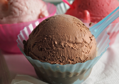 Three plastic caps of flavored gelato on a napkin 