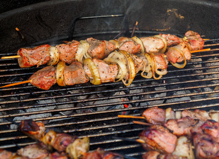 Shish kebabs on skeweres are cooked on a charcoal grillの写真素材