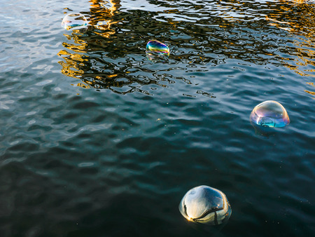 Bright large soap bubbles on the water surface
