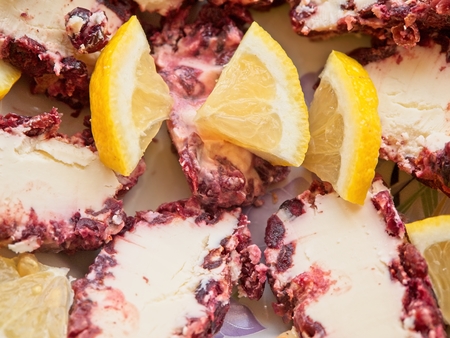 Plate with several kinds of cheese and slices of lemon on granite counterの写真素材