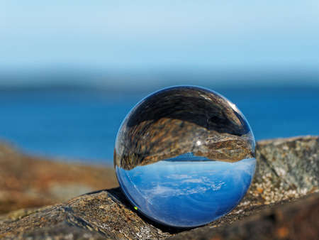 Spectacular rocky shore of Sidney BC with beautiful skies reflects in the lens ballの写真素材