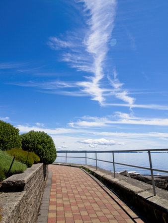 Spectacular clouds over Sidney BC shoreline, seaside boardwalkの写真素材