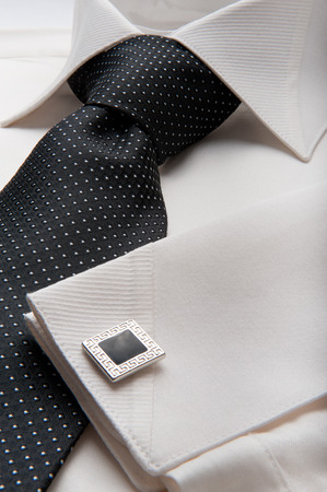 Close up photo of a folded formal white men shirt with a black tieの写真素材