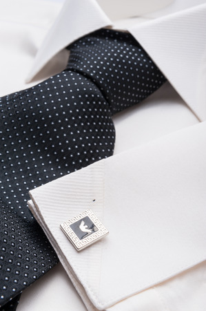 Close up photo of a folded formal white men shirt with a black tieの写真素材