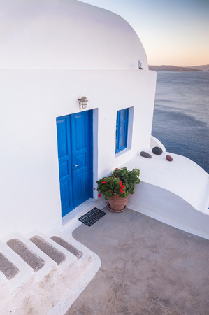 Entrance to a typical greek home with white walls and blue door in Oia city, Santorini island, Greeceの写真素材