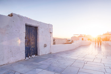 People on a promenade on Marmorikatu street in Oia city on Santorini during a sunsetの写真素材