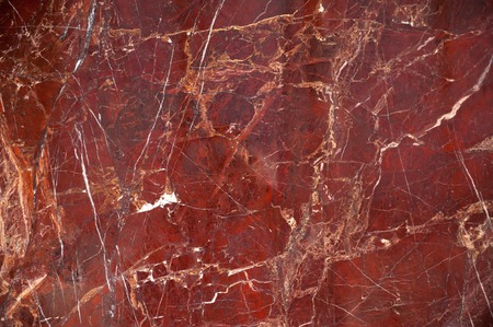 Red marble onyx texture with brown and white stripes and cracksの写真素材