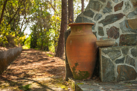 An old garden pot, made of baked clay. Very nice rustic like, old garden jar, a replica of ancient Greece pots, settled in the quite part of garden waiting for new flowers to be put in.の写真素材