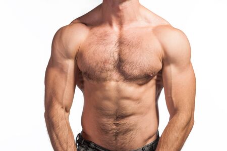 Studio photo of a shirtless man with strong torso and abdomen muscles. Waist up close up photo of the chest, hands and abdomen.の写真素材