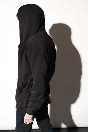 Contemporary Fashion portrait of young man posing against a white background with contrast shadowsの写真素材