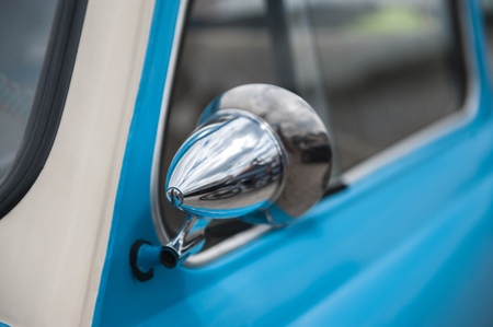 Closeup shot of a side mirror of a bright blue soviet retro carの写真素材