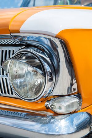 Closeup shot of a head lamps of a bright orange soviet retro carの写真素材