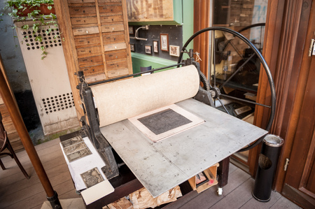 An old, antique, manually operated letterpress printing machine in Lviv, Ukraine. This press is used to create postcards with the Lviv's landscapes.の写真素材