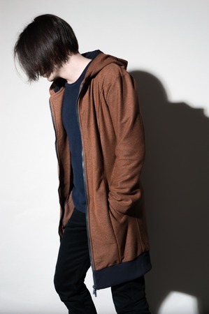 Contemporary Fashion portrait of young man posing against a white background with contrast shadowsの写真素材
