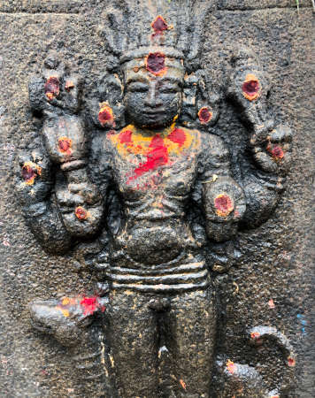 God sculpture with decorations during festival. Bas relief sculpture carved in the stone walls at Shiva temple in Tamil naduの写真素材