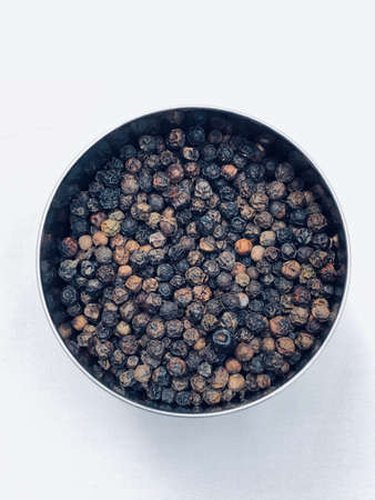 Black pepper in a bowl with white backgroundの写真素材
