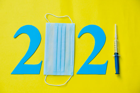 2021 new year concept of usage of face mask and vaccine for corona virus pandemic situation. Happy...