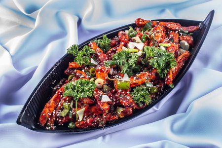 Chilli potato or Potato wedge garnished with sesame and onion is a popular Indian-Chinese food.の写真素材