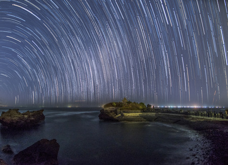 startrail over a temple in mengening beach Bali at night