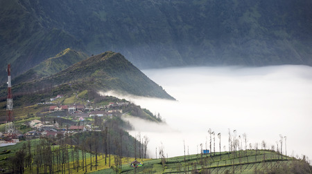 Mist flowing over Cemoro Lawang village in the morning located to northeast of Mt Bromo, Indonesia
