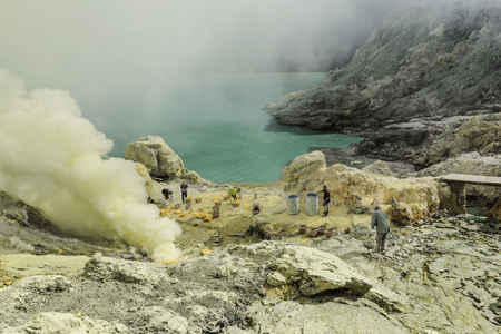 East Java, Indonesia June 2015: Sulphur miners involved in mining activities in Kawah Ijen volcano which is an active volcano has active vent at the edge of the lake is a source of elemental sulphur.のeditorial素材