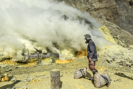 East Java, Indonesia June 2015: Sulphur miners involved in mining activities in Kawah Ijen volcano which is an active volcano has active vent at the edge of the lake is a source of elemental sulphur.のeditorial素材
