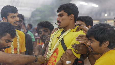 SINGAPORE 2015: Hindu Devotees get pierced in their mouth with a needle and carry milk pot for Lord Muruga  during annual Hindu festival Thaipusam in Singapore.のeditorial素材