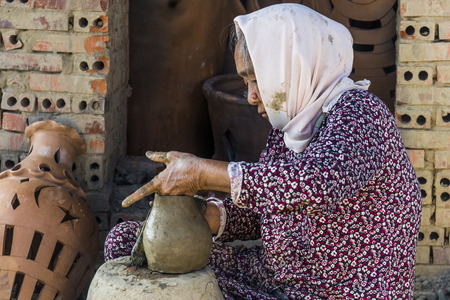 Vietnam December 2017: Local Vietnamese woman molding pot from clay mixture in her factory, Vietnamのeditorial素材