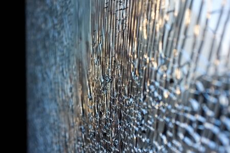 Tempered glass cracked closeup, background with copy spaceの写真素材