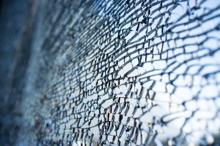 Tempered glass cracked closeup, background with copy spaceの写真素材