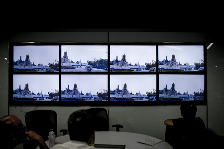 BANGKOK, THAILAND, OCT 14, 2016 - Reporters in The Nation editorial watching the Thousands mass along streets as his Majesty's body was taken from Siriraj Hospital to the Grand Palace on live TV.のeditorial素材