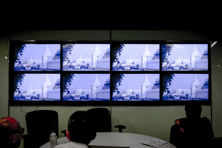 BANGKOK, THAILAND, OCT 14, 2016 - Reporters in The Nation editorial watching the Thousands mass along streets as his Majesty's body was taken from Siriraj Hospital to the Grand Palace on live TV.のeditorial素材