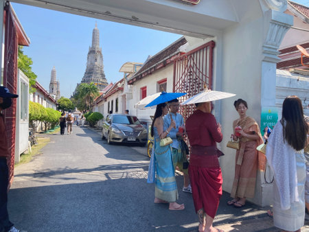 BANGKOK, THAILAND - FEBRUARY 8, 2023: Chinese tourists like to dress in traditional Thai costumes to visit Thai temples. Pictured is at Wat Arun (Temple of Dawn), Bangkok, Thailandのeditorial素材