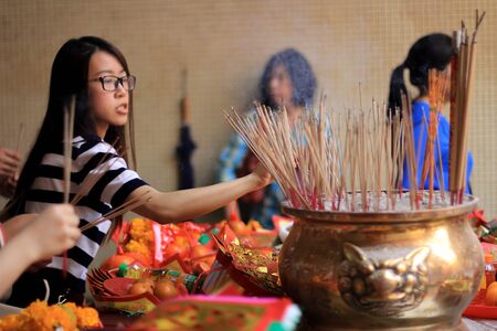 Bangkok/Thailand - April 19 2016 : thai woman putting incense sticks into a sand pot to worship the chinese god in chinese templeのeditorial素材