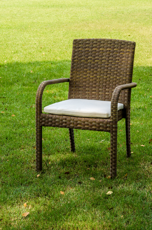Brown rattan chair with cushion in the gardenの写真素材
