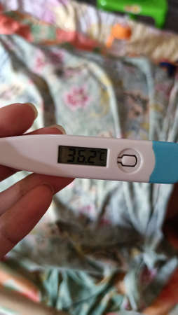Digital thermometer in the hands of a girl. High quality photo