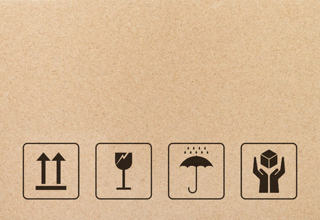 Black fragile sign and symbol on brown cardboard paper. Fragile symbol illustration graphic.の写真素材