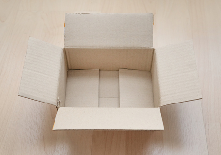 Empty open rectangular cardboard box on wood background. Shopping online object background. Shipping...