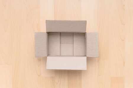 Empty open rectangular cardboard box on wood background. Shopping online object background. Shipping...